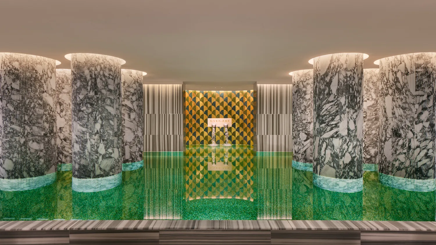 Indoor pool at the Bvlgari Hotel Roma. Green tiled pool with marble columns.