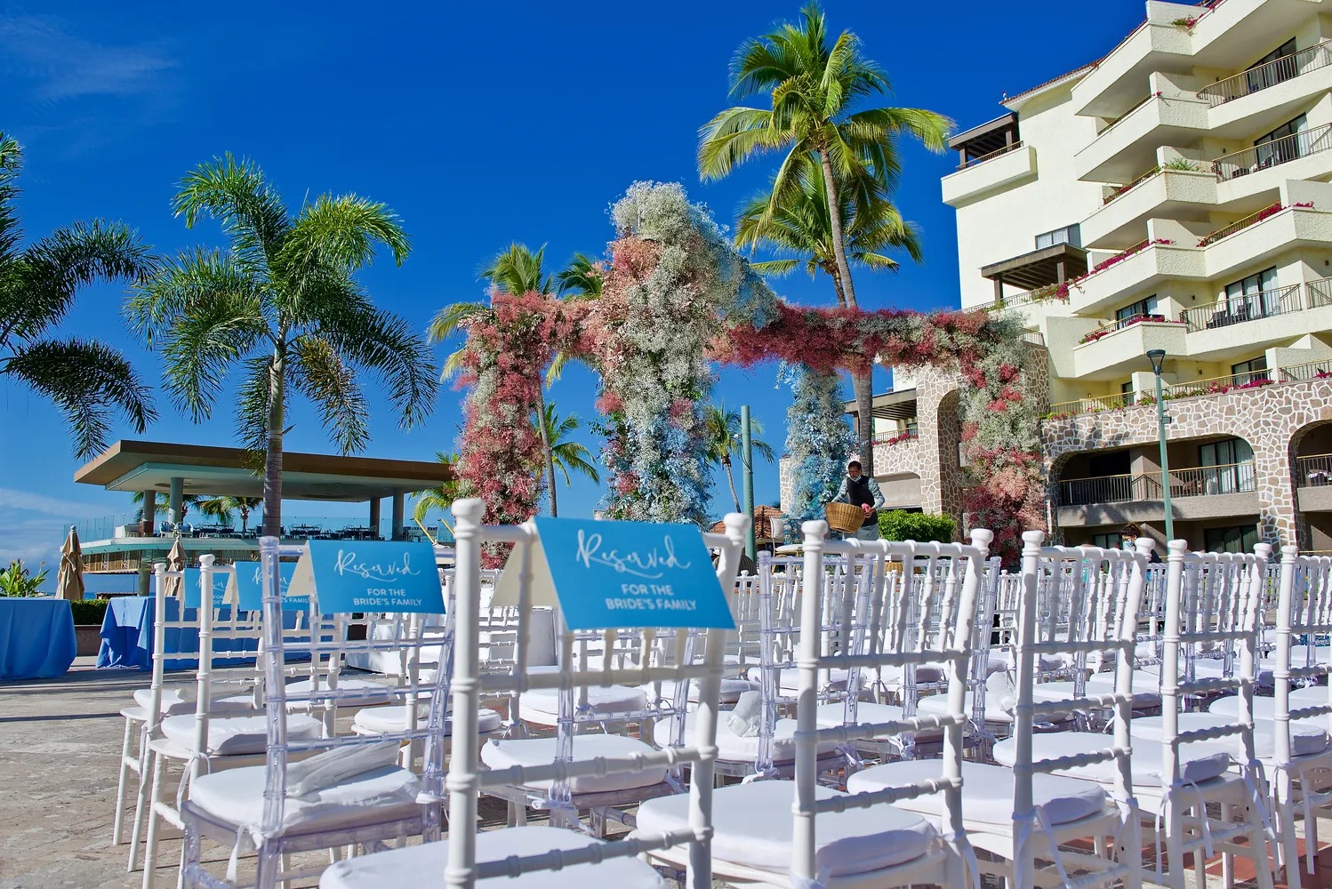 Reserved seating for the bride's family at a destination wedding in Puerto Vallarta. White chairs and floral arch.