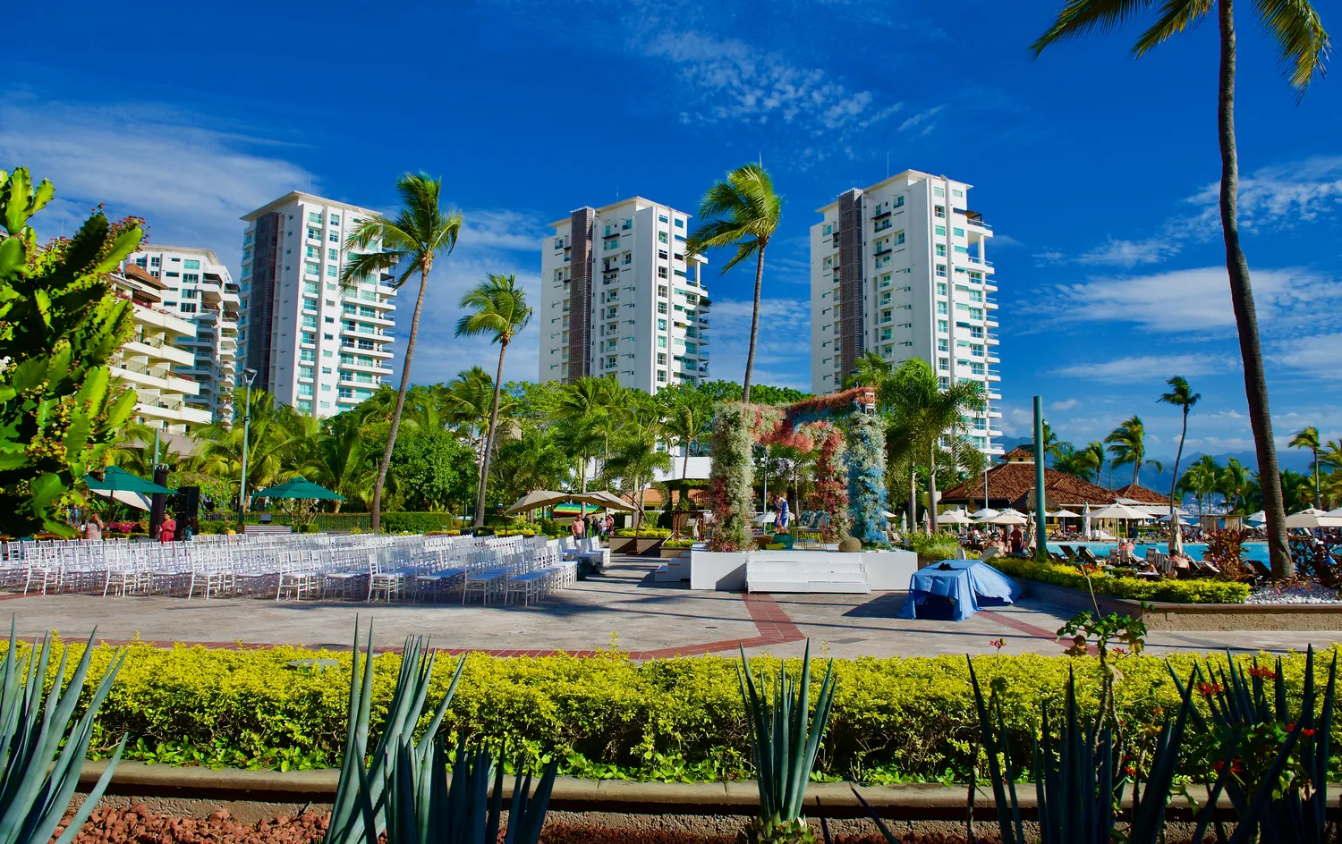 Destination wedding setup at Marriott Puerto Vallarta, featuring white chairs and floral arch.