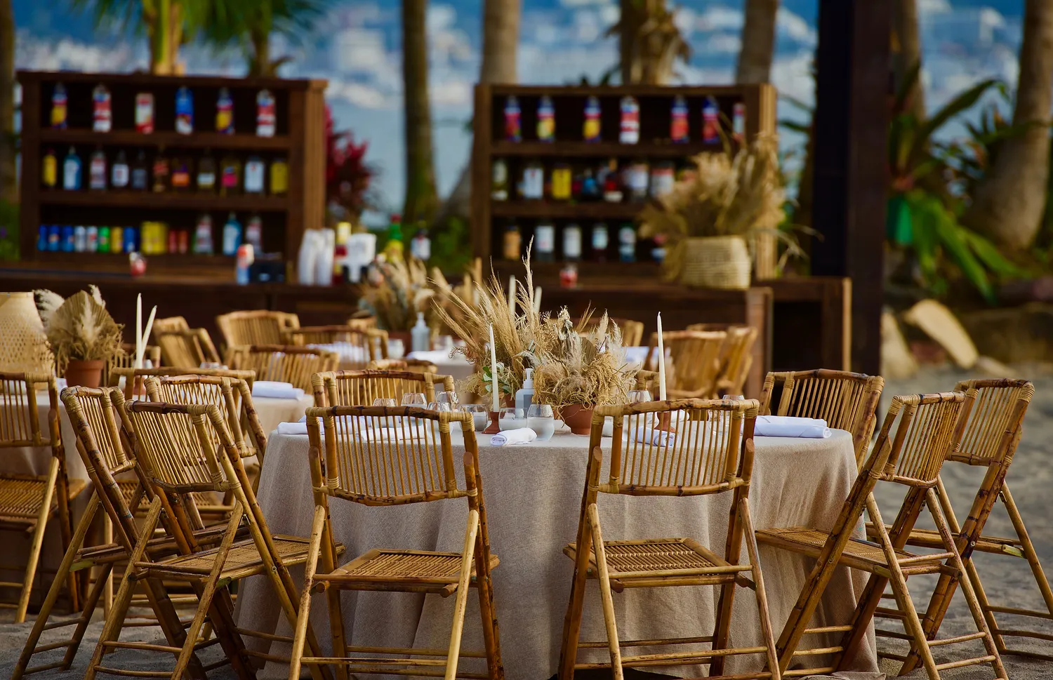 Beachfront destination wedding reception in Puerto Vallarta at the Marriott. Elegant bamboo chairs surround a table with pampas grass centerpiece.
