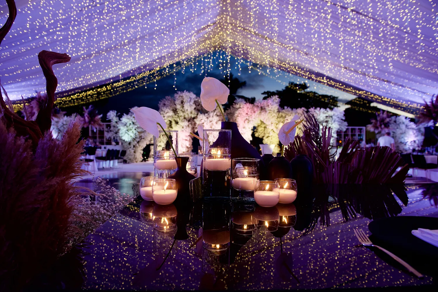 Romantic candlelit wedding reception table at a Puerto Vallarta resort, featuring white flowers and elegant décor.