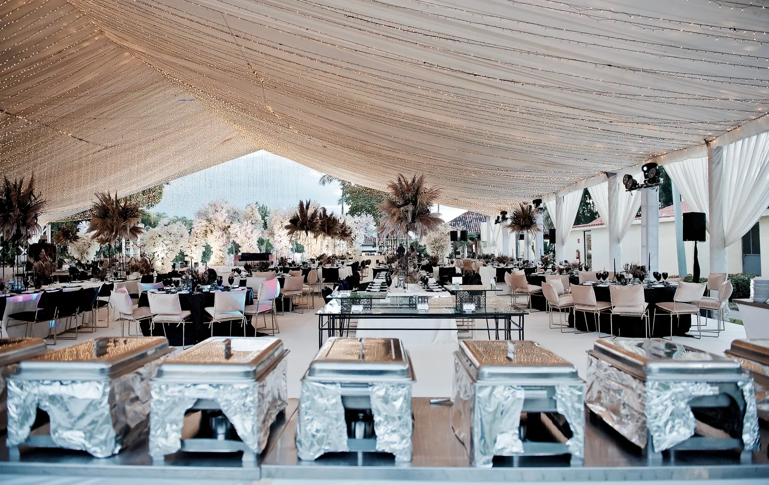 Elegant wedding reception setup under a tent at a Puerto Vallarta resort. Destination wedding decor.