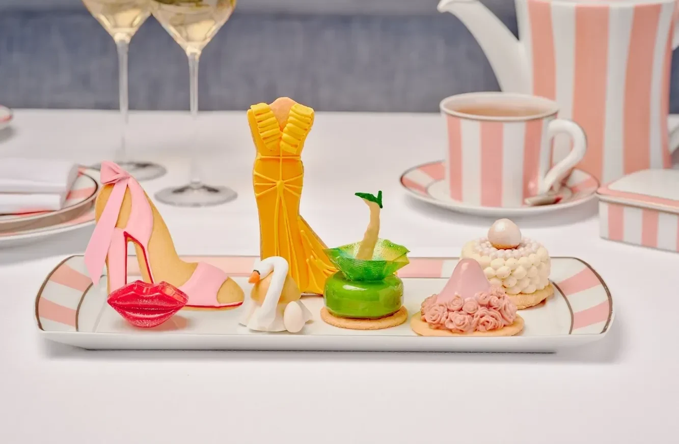 Elegant pastries arranged on a plate, featuring a high-heeled shoe and dress-shaped cookies. Perfect for a Beverly Hills wedding.
