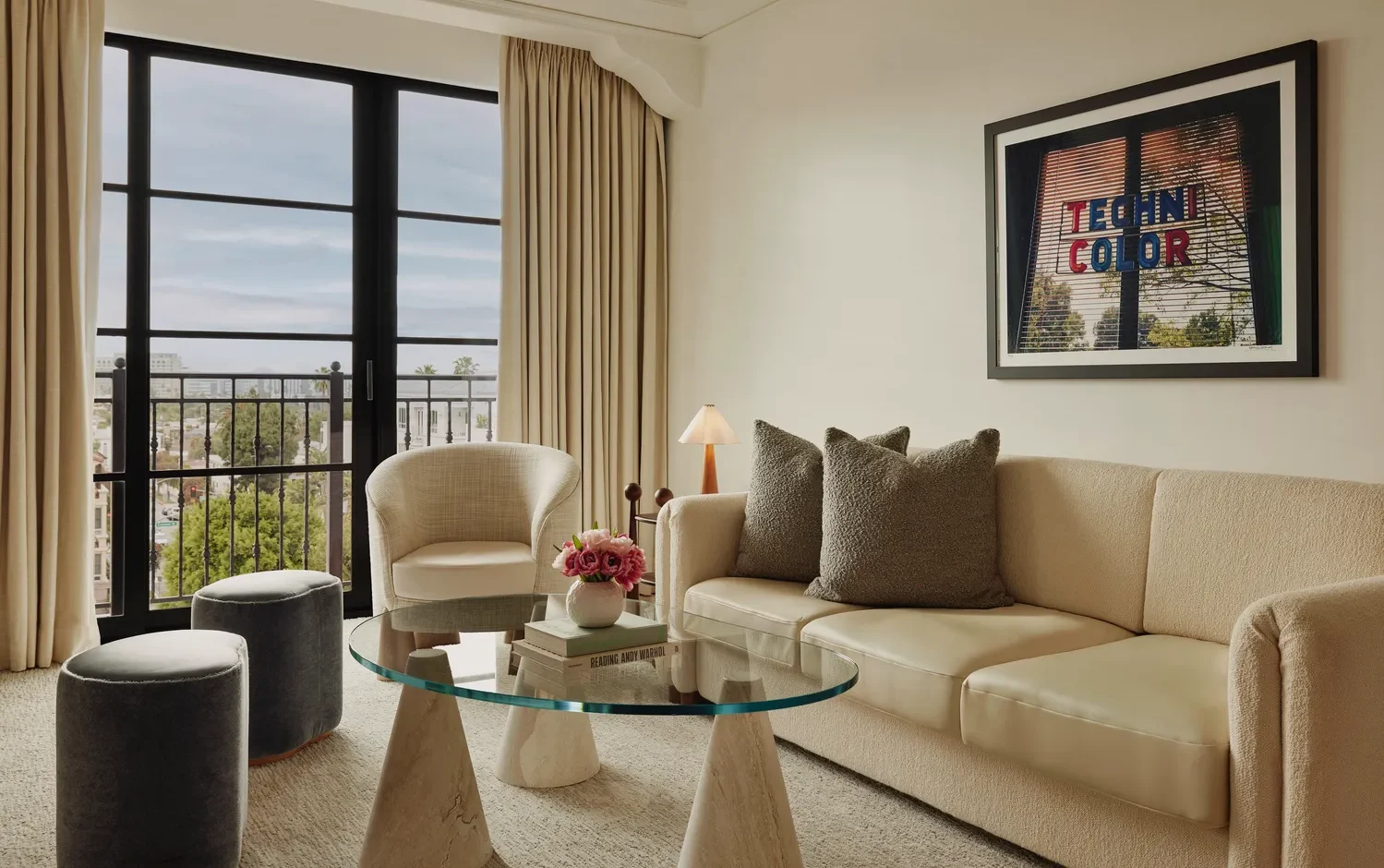 Luxurious living room at the Maybourne Beverly Hills, featuring a beige sofa and city view.