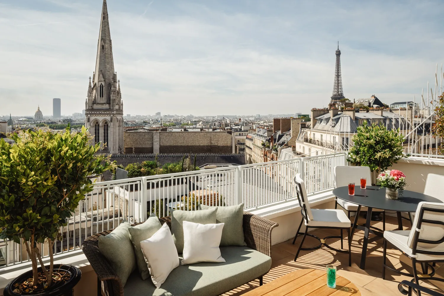 Paris rooftop terrace with Eiffel Tower view, luxury seating, and table