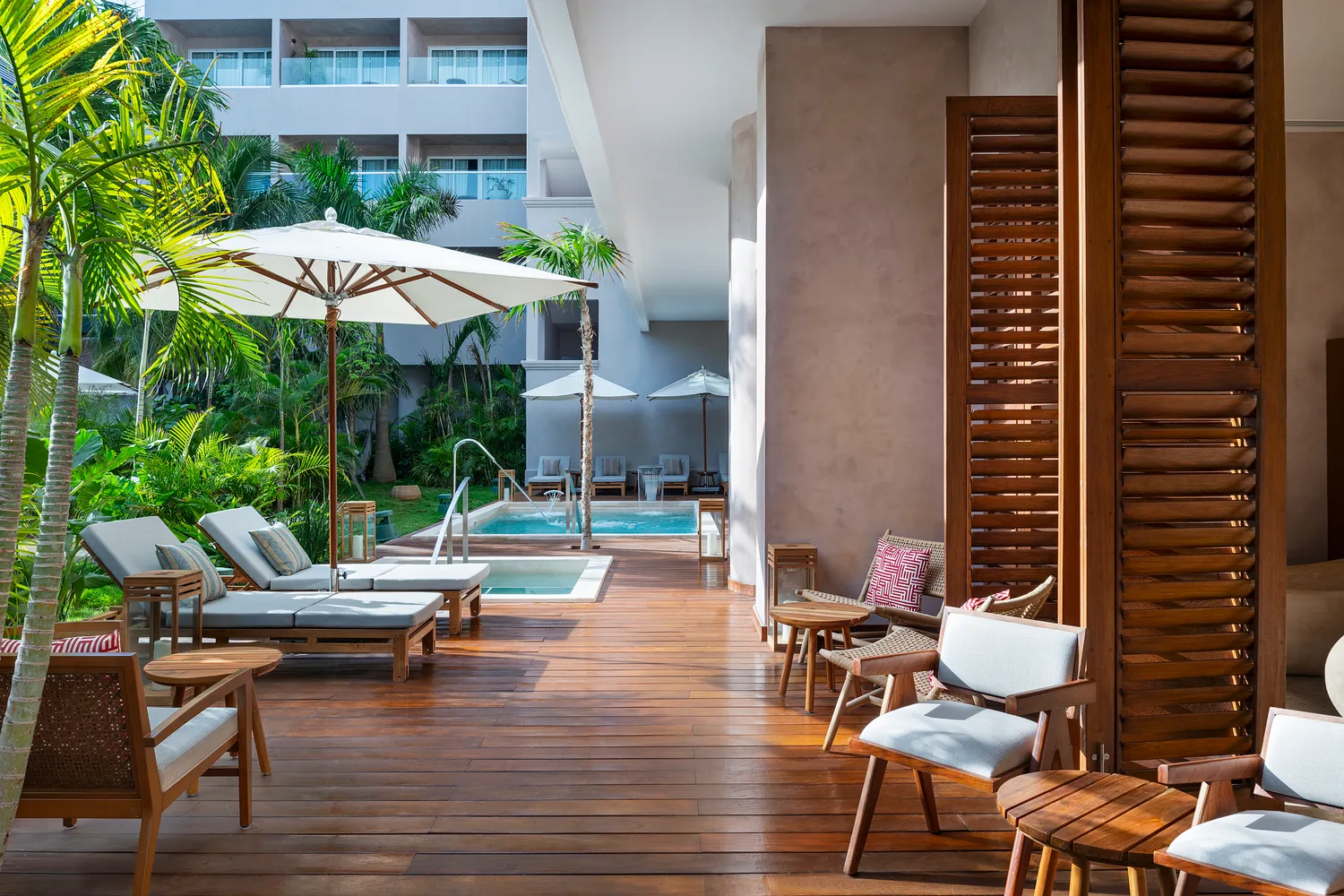 Luxury suite patio at Almare Isla Mujeres resort with private plunge pool and lounge chairs.