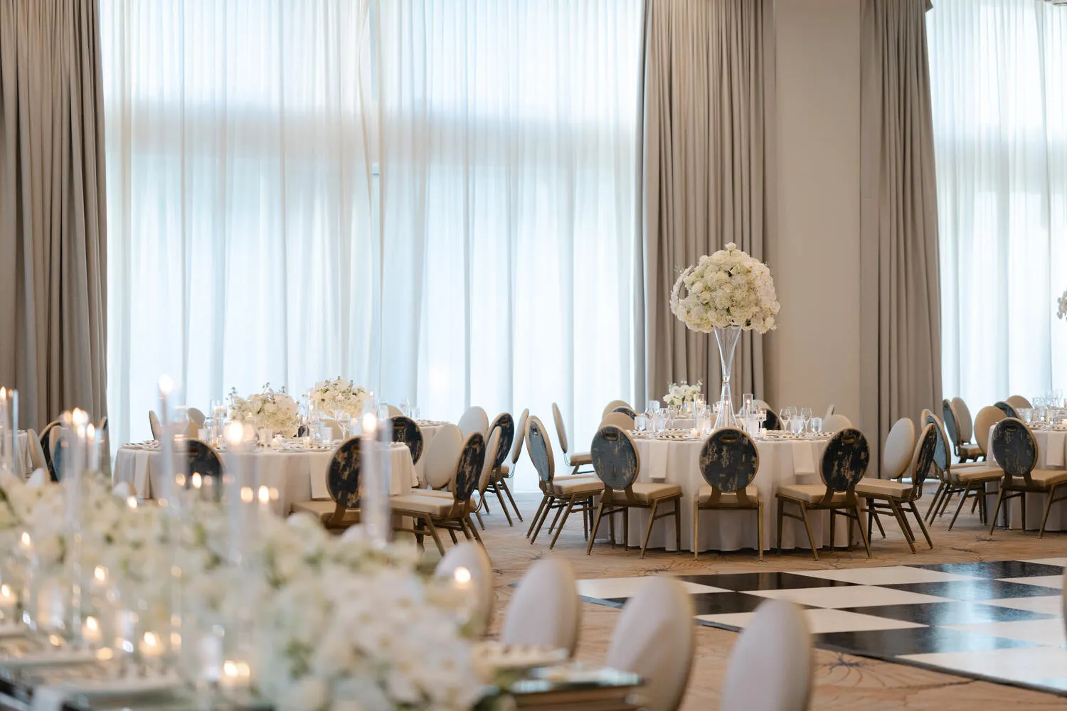 Elegant wedding reception at Pier Sixty-Six, a Fort Lauderdale wedding venue. Tables with white linens and floral centerpieces.