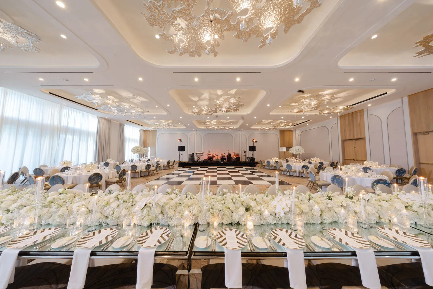 Elegant wedding reception at Pier Sixty-Six, a Fort Lauderdale wedding venue. Long head table with white floral arrangements.