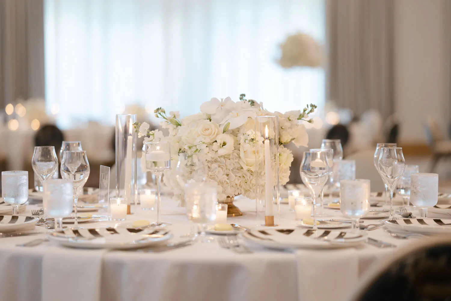 Elegant white floral centerpiece and candlelight at a Fort Lauderdale wedding reception.