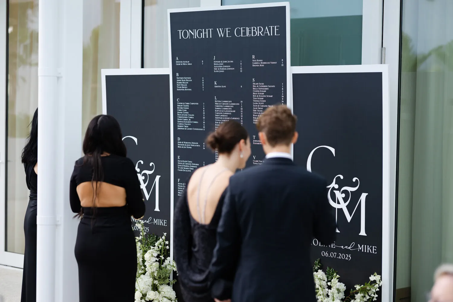 Guests in formal attire reading wedding signage at Fort Lauderdale venue