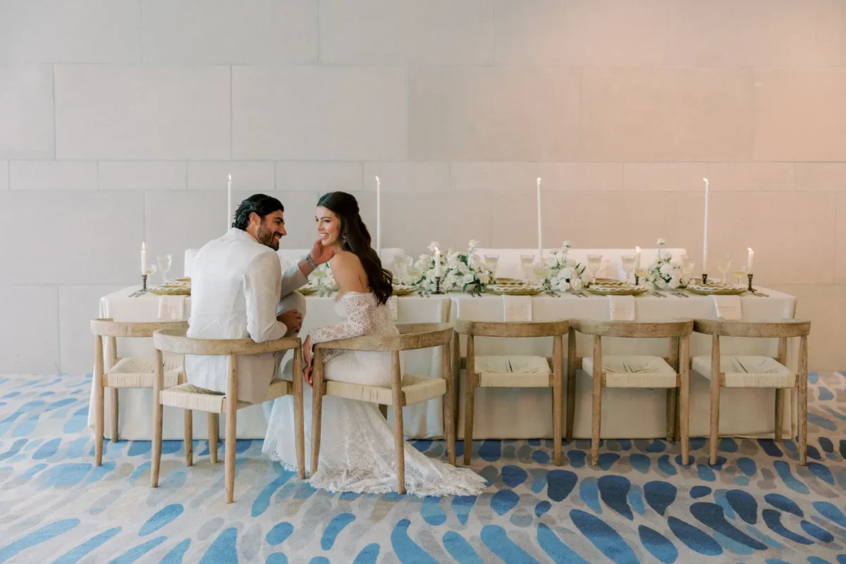 Bride and groom seated at their wedding reception at the Conrad Orlando, gazing lovingly at each other.
