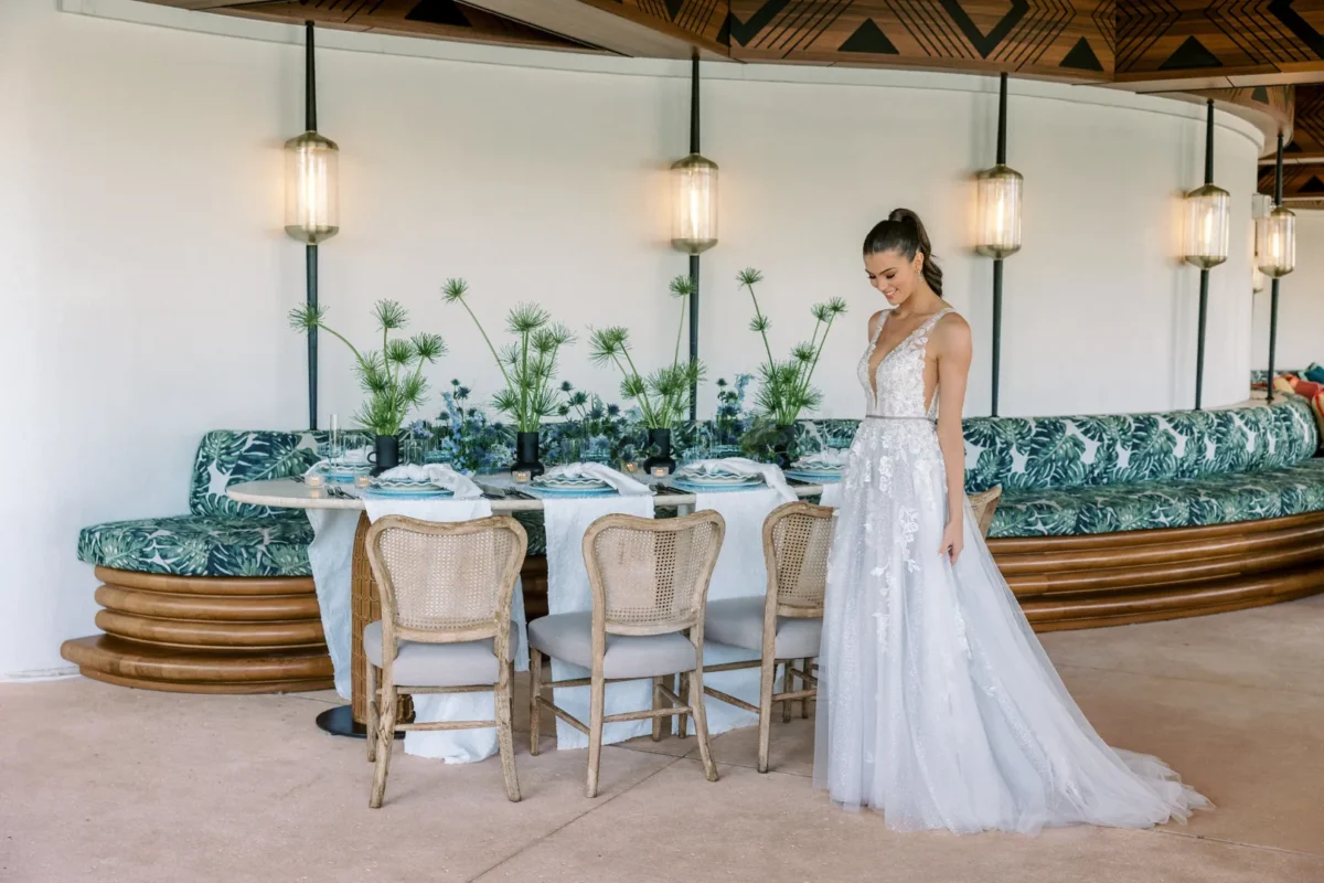 Bride in a wedding gown stands near a wedding reception table at the Conrad Orlando.