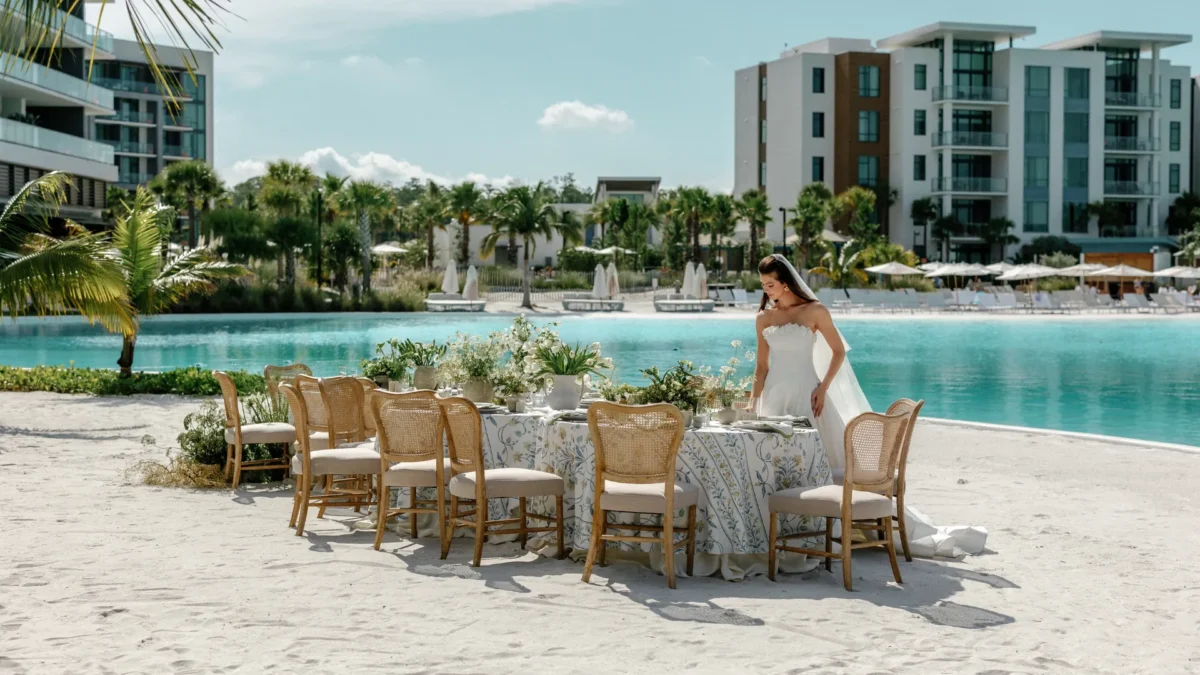 Bride arranging wedding table on a beach at the Conrad Orlando resort.