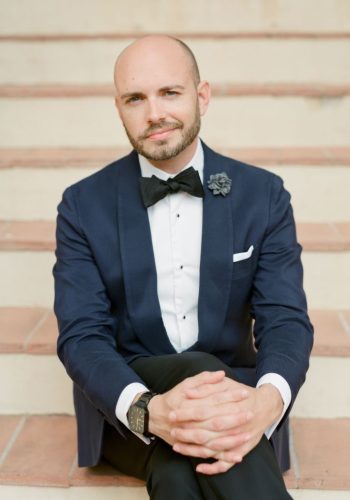 Man in formal attire seated on stairs